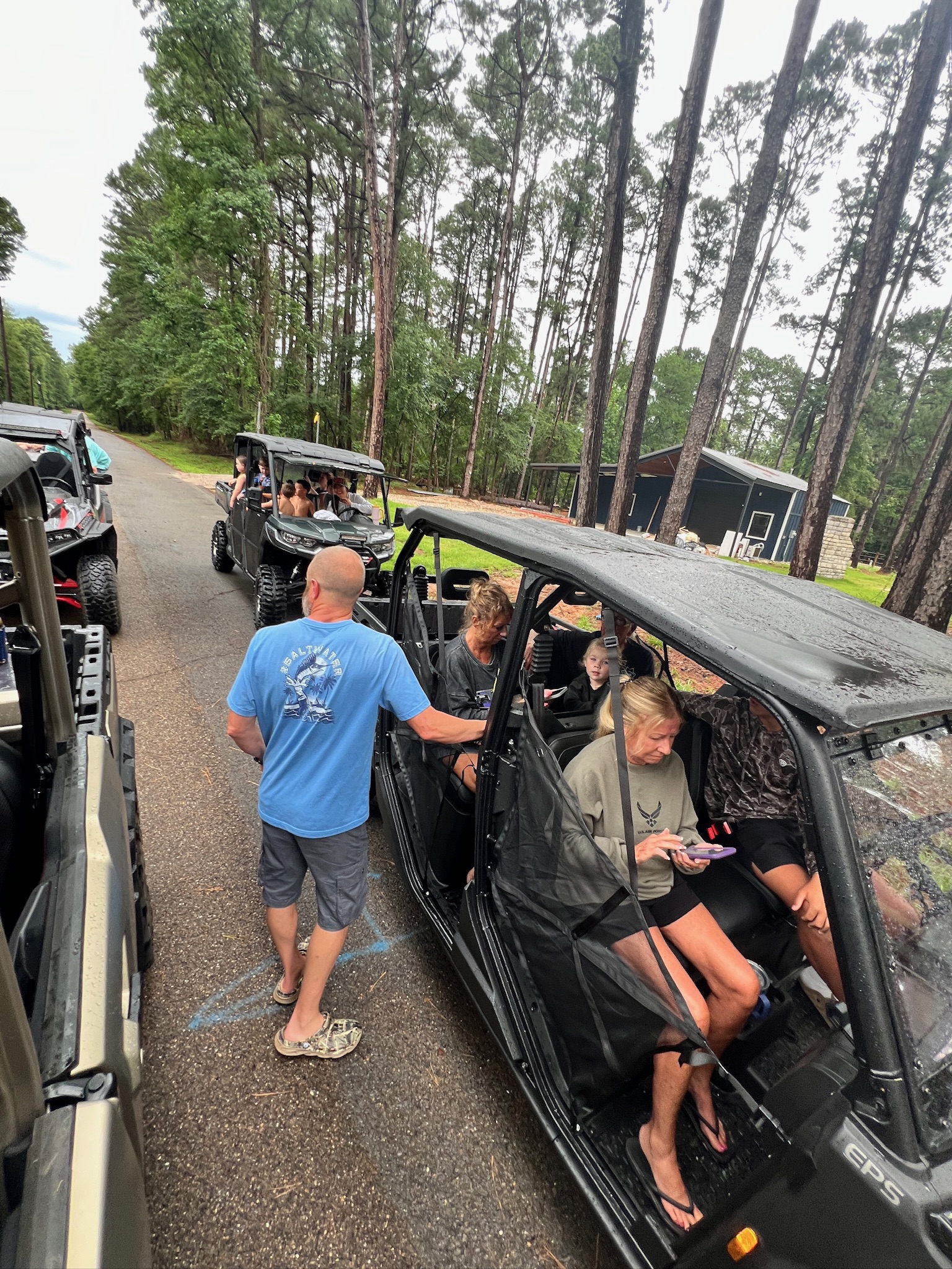 Can Am side by side parked in the woods with family preparing for a hiking adventure in a scenic pine forest.